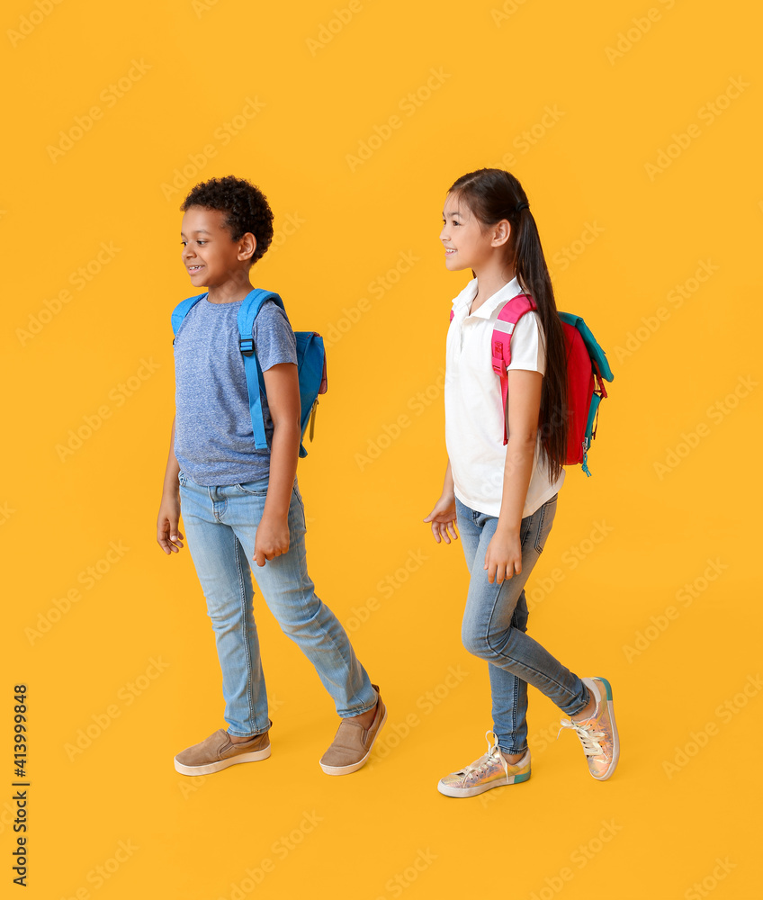 Little schoolchildren on color background