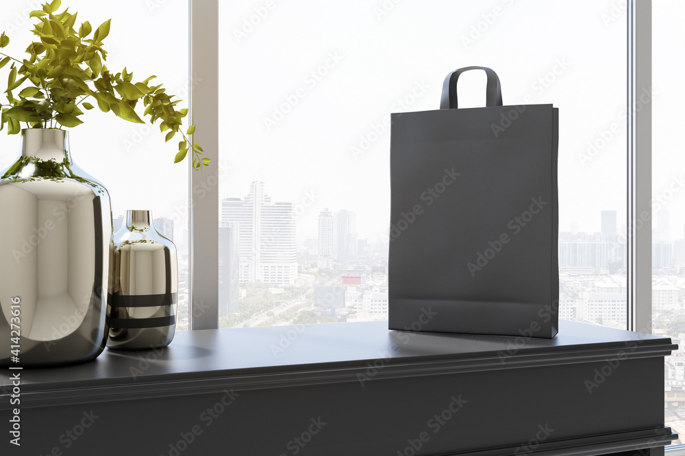 Sunny room area with steel vases on dark wooden surface and empty black paper bag. Mockup