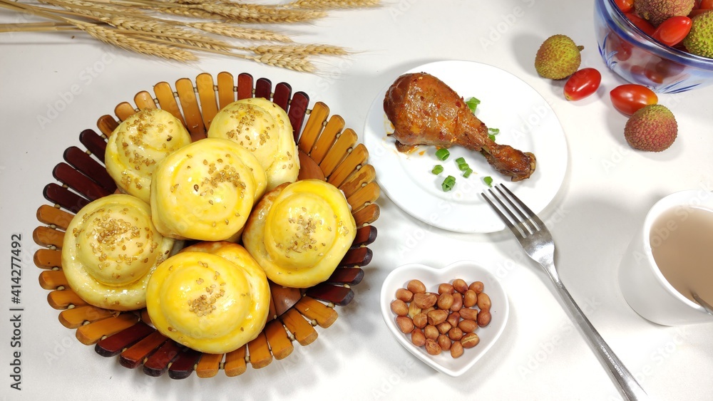 Healthy and nutritious Chinese breakfast, homemade bread, chicken drumstick, peanuts and fruits