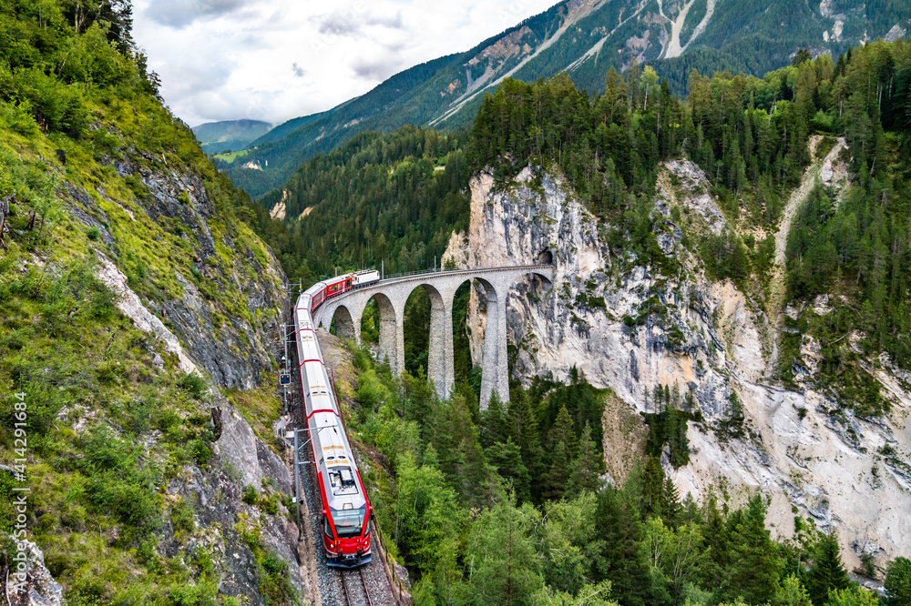 Passenger train crossing the Landwasser Viaduct in the Swiss Alps