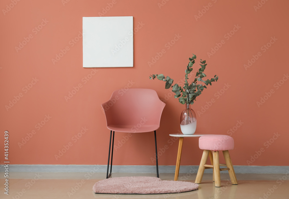 Chair and table near color wall in room