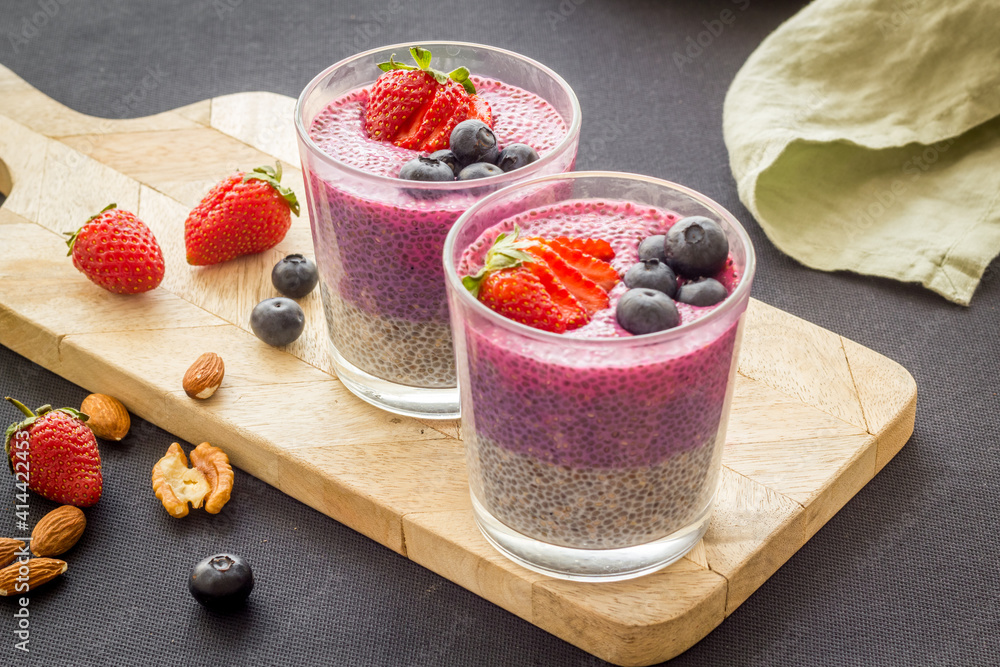 Chia pudding smoothie dessert wirh strawberries in glass jars. Vegan healthy breakfast.