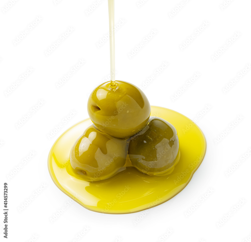 Pouring olive oil on olives placed on a white background