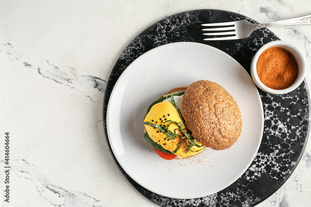 Plate with tasty burger and florentine egg on light background