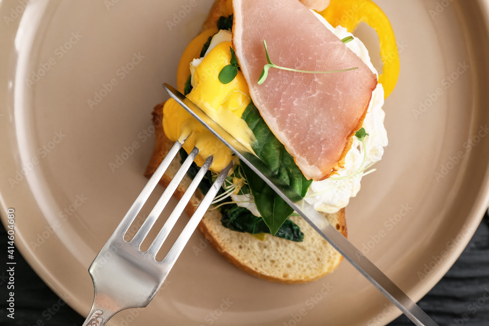 Tasty sandwich with florentine egg and bacon on plate, closeup