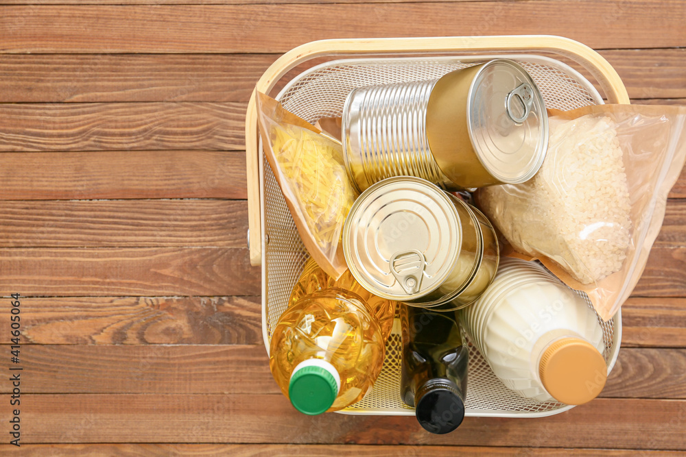 Basket with different products on wooden background