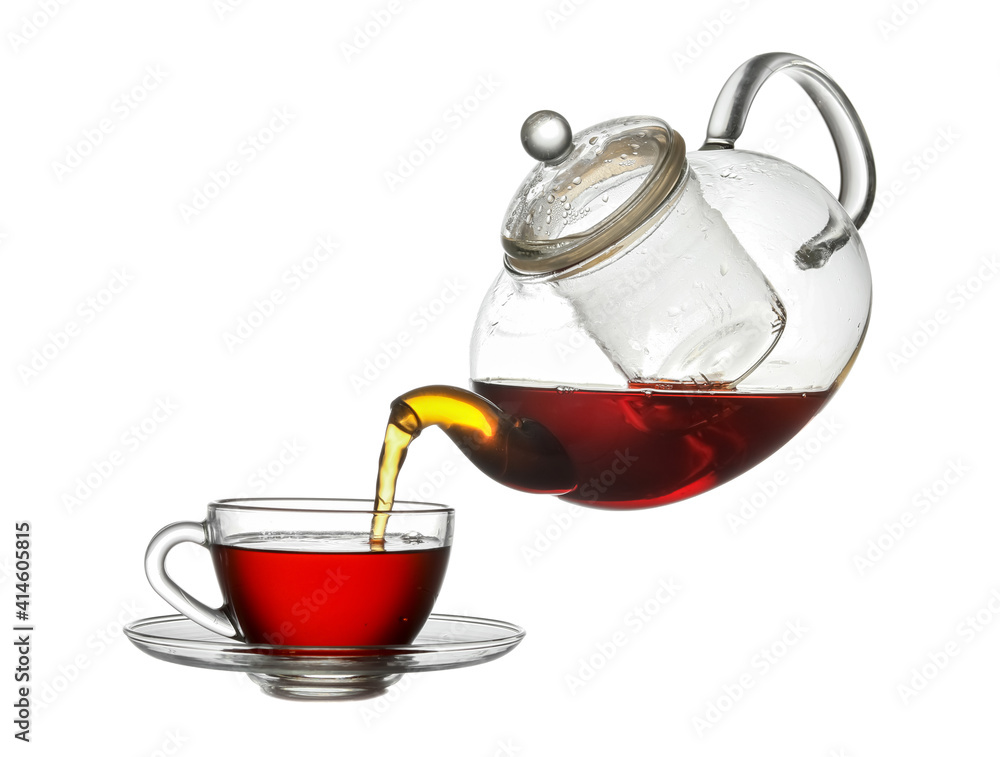 Pouring of hot tea from teapot into cup on white background