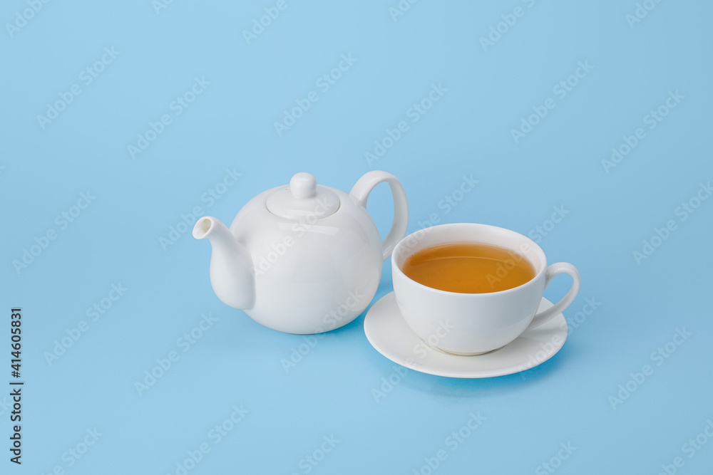 Stylish teapot and cup of tea on color background