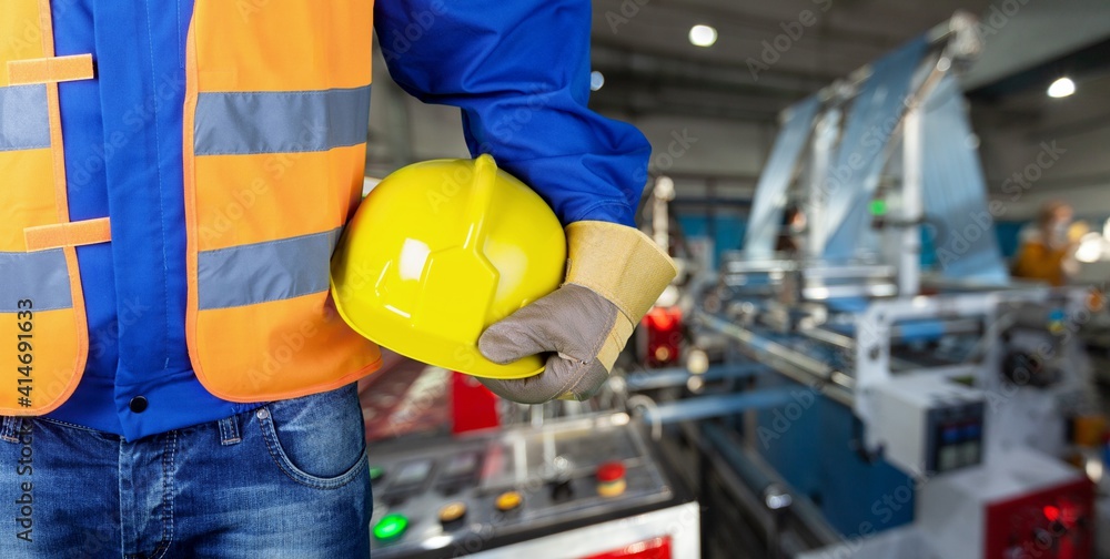 Worker man with helmet in hands on background