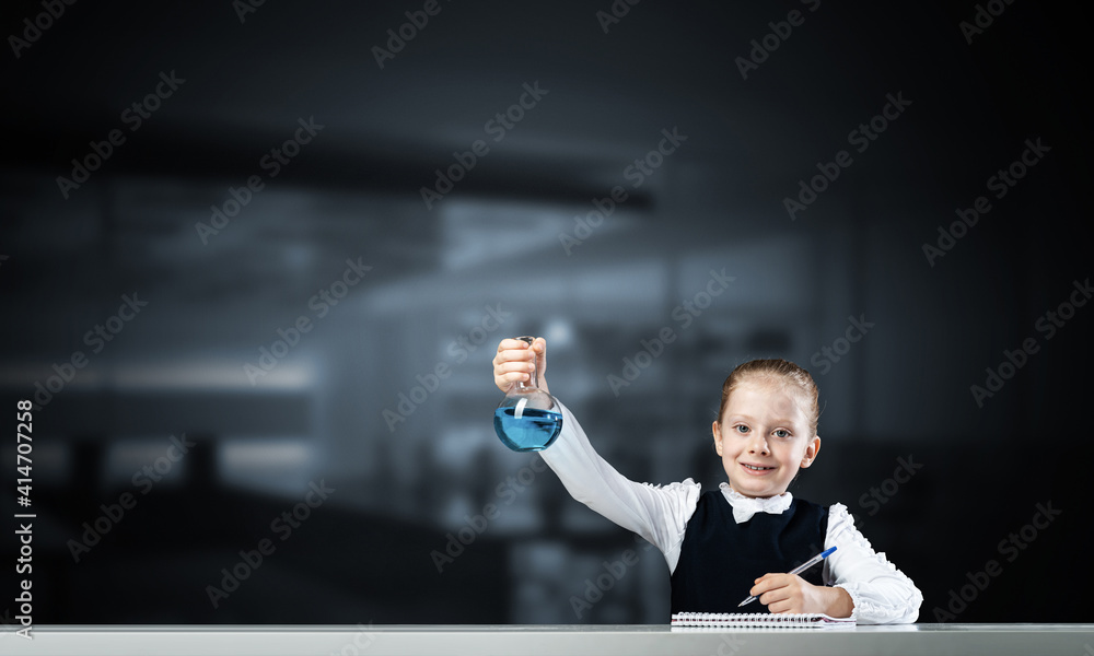 Little girl scientist examining test tube