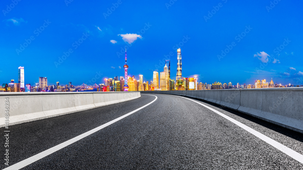 Empty asphalt road and Shanghai skyline with buildings at night.