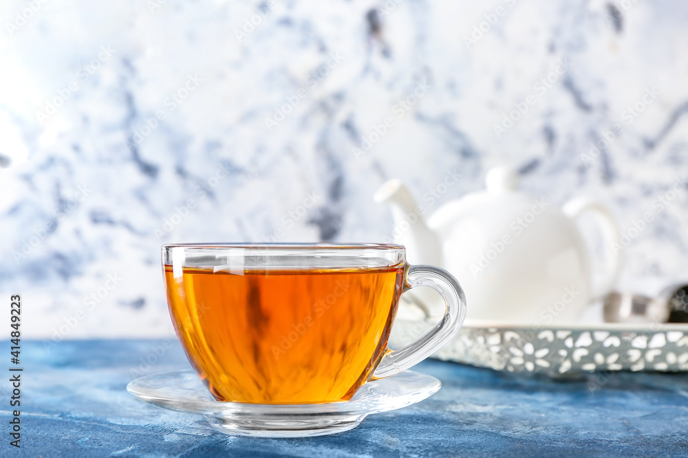 Cup of hot tea on color background