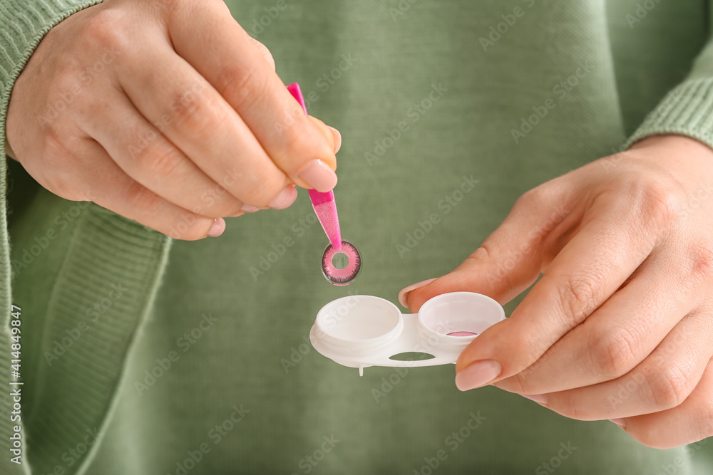 Woman taking contact lens from container, closeup