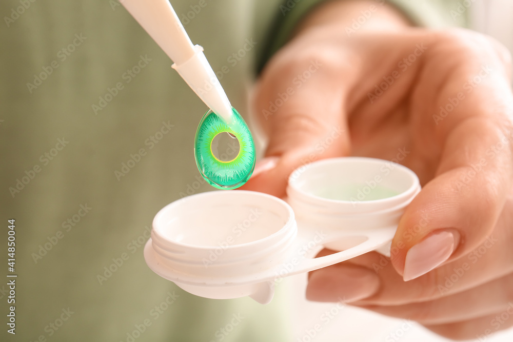 Woman taking contact lens from container, closeup