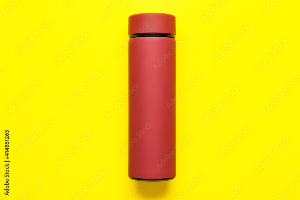 Modern thermos on color background