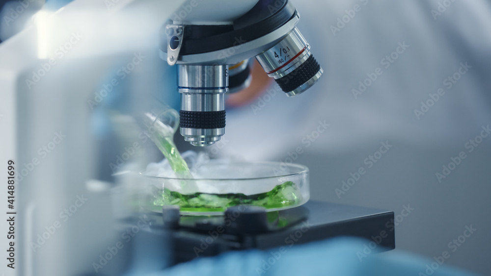 Macro Close Up Shot of a Scientist Mixing Green Chemical Liquid Under the Microscope on a Sample Pet