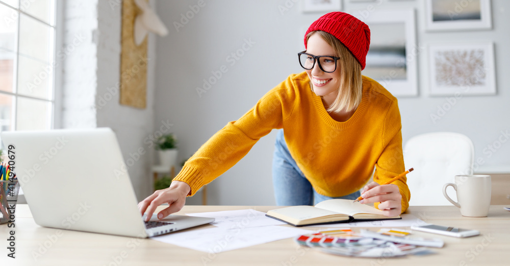 Cheerful freelancer making notes during work at home