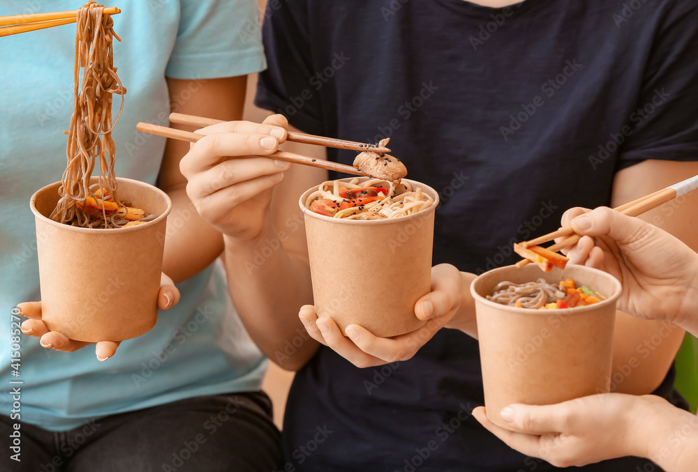 Women eating tasty noodles, closeup