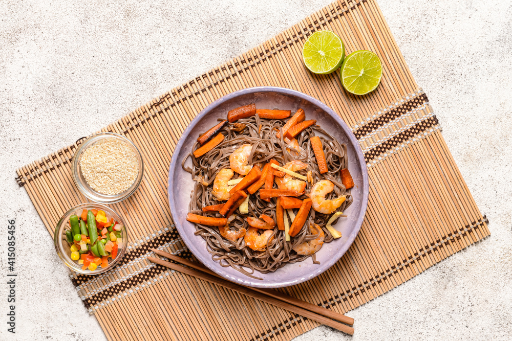 Plate with tasty soba noodles and shrimps on light background