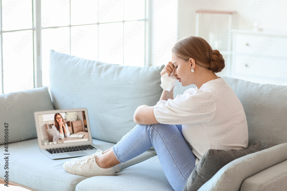 Stressed young woman asking psychologist for advice online at home