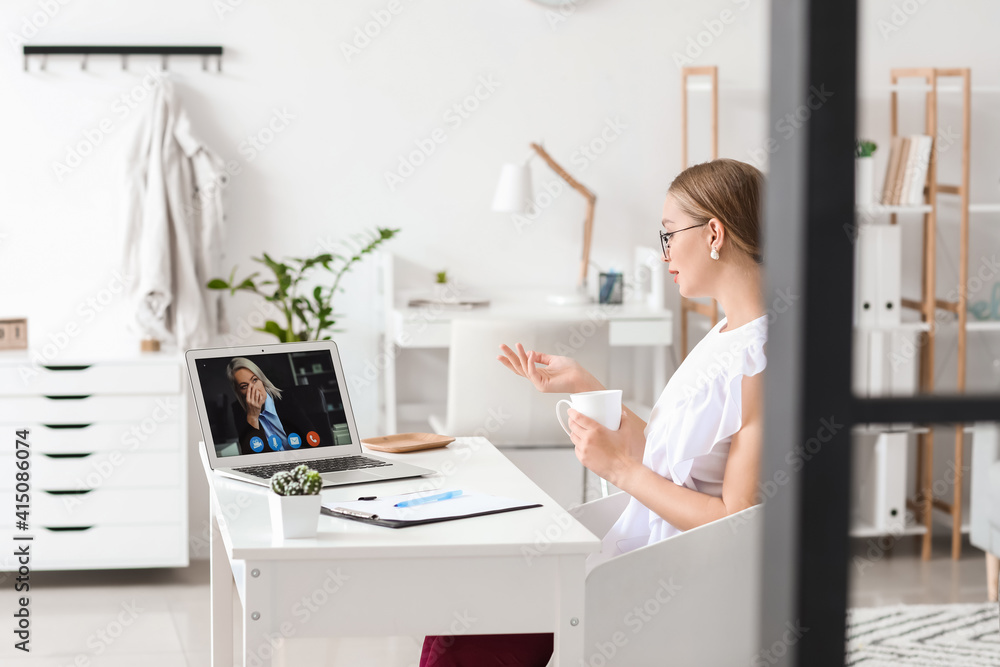 Psychologist working with patient online while sitting in office