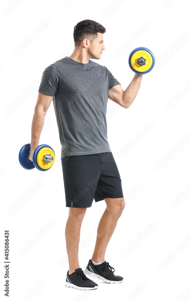 Sporty young man training with dumbbells on white background