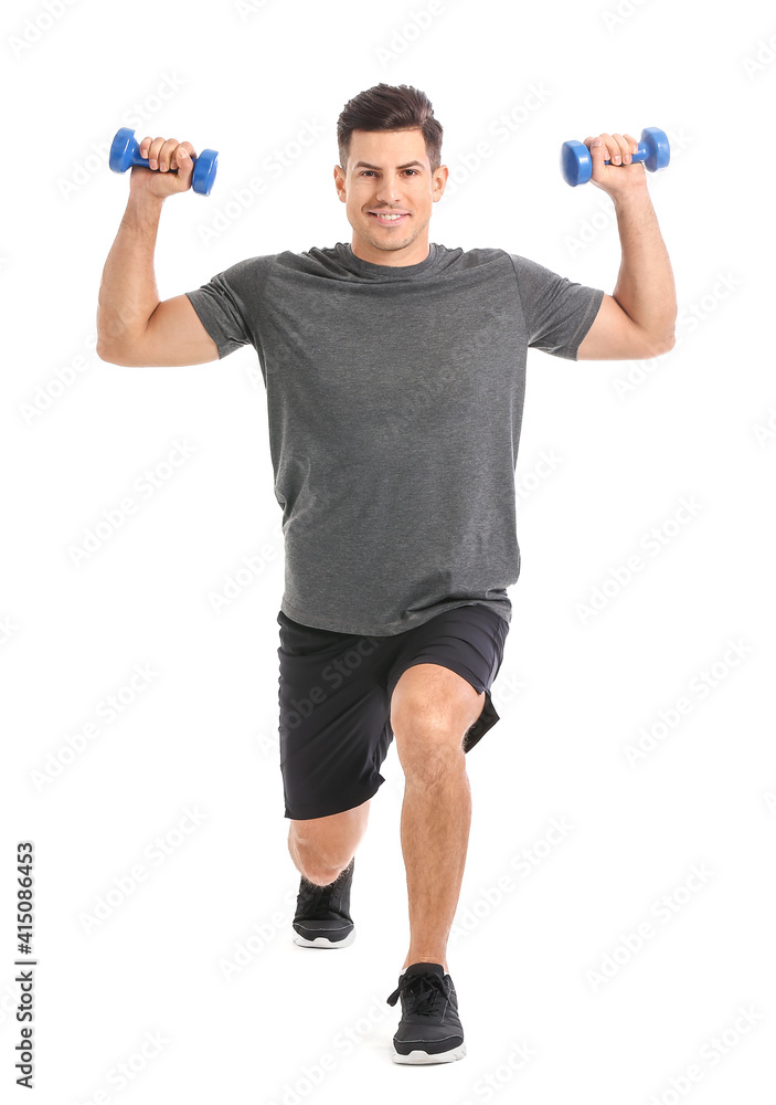 Sporty young man training with dumbbells on white background