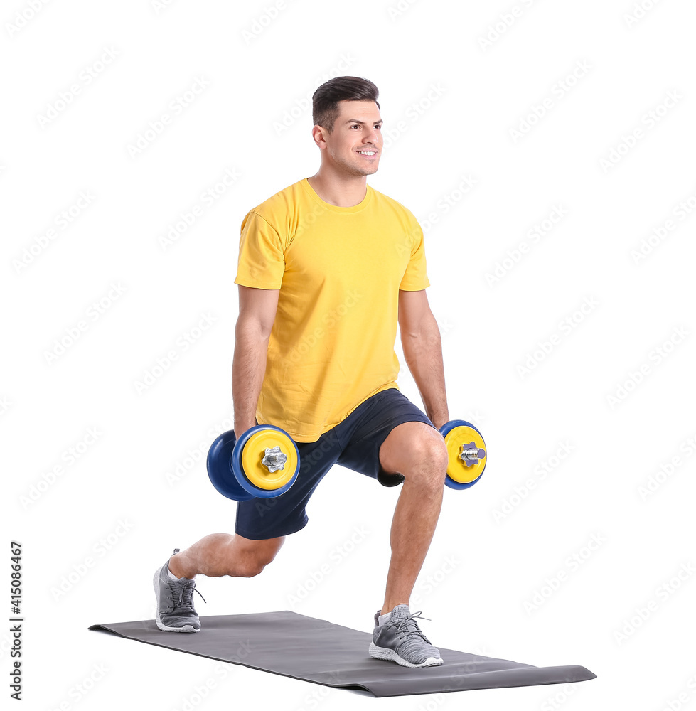 Sporty young man training with dumbbells on white background