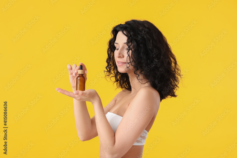 Beautiful young woman with cosmetic serum on color background