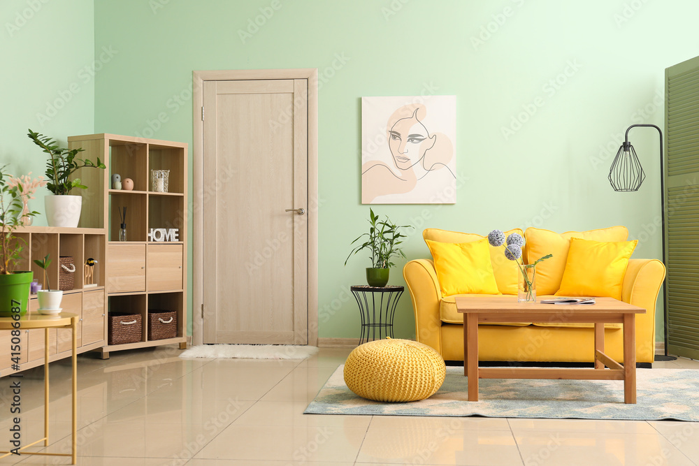 Interior of modern living room with stylish sofa and wooden shelving unit