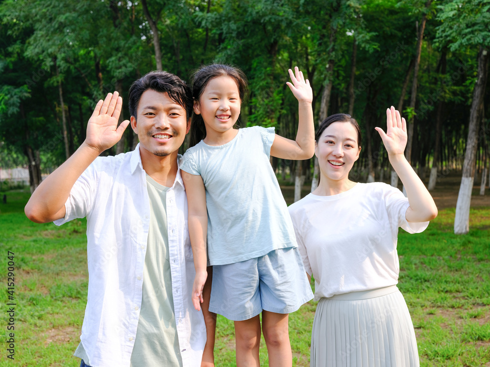 Happy family of three playing in the park