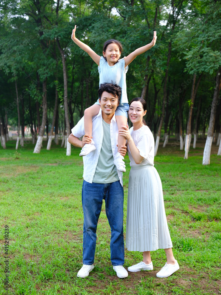 Happy family of three playing in the park