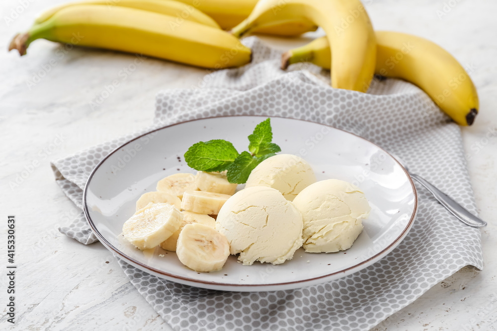 Plate with tasty ice cream and bananas on light background