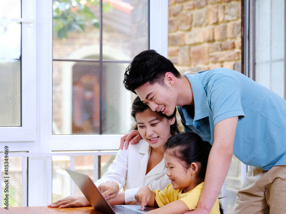 Happy family of three using laptop