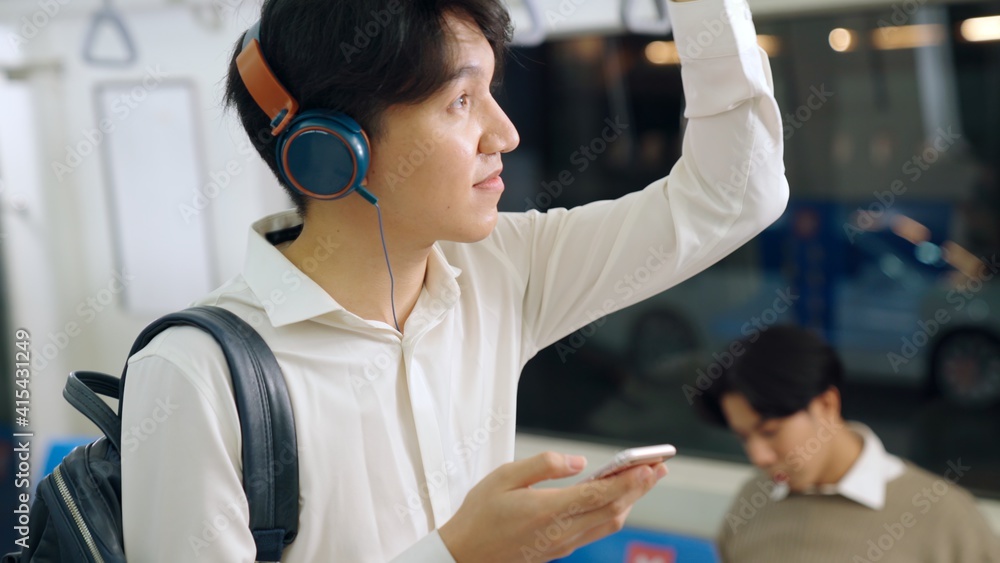 Businessman using mobile phone on public train . Urban city lifestyle commuting concept .