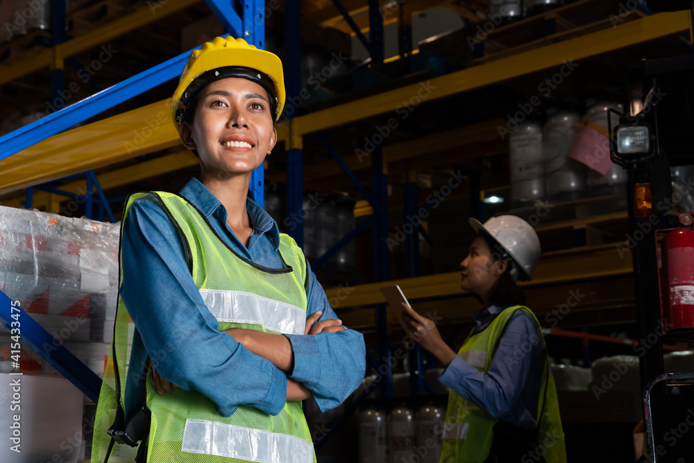 Portrait of young woman warehouse worker smiling in the storehouse . Logistics , supply chain and wa