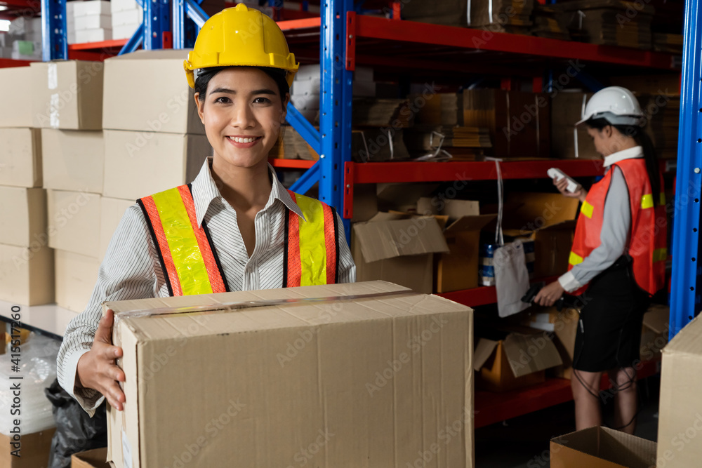 Portrait of young Asian woman warehouse worker smiling in the storehouse . Logistics , supply chain 