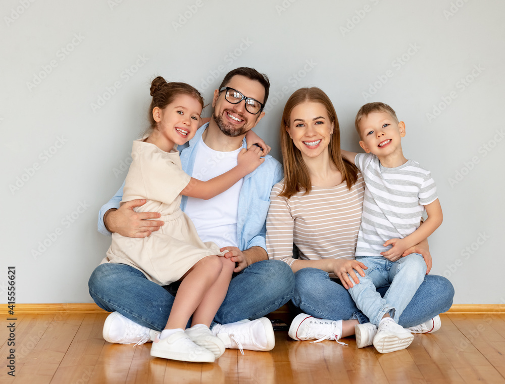 Happy parents with kids sitting in empty room