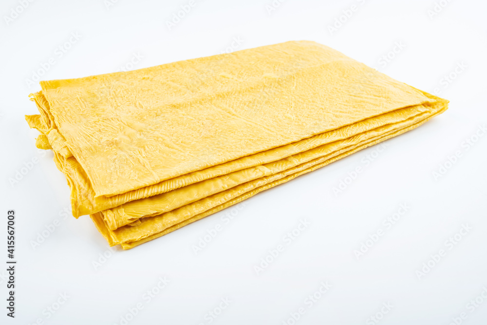 Golden dried tofu skin on white background