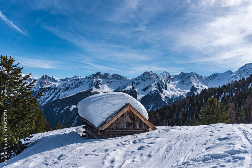 Schneebedeckte Hütte mit Bergpanorama