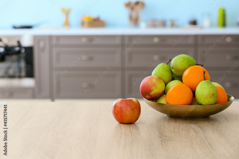 Plate with fruits on table in modern kitchen