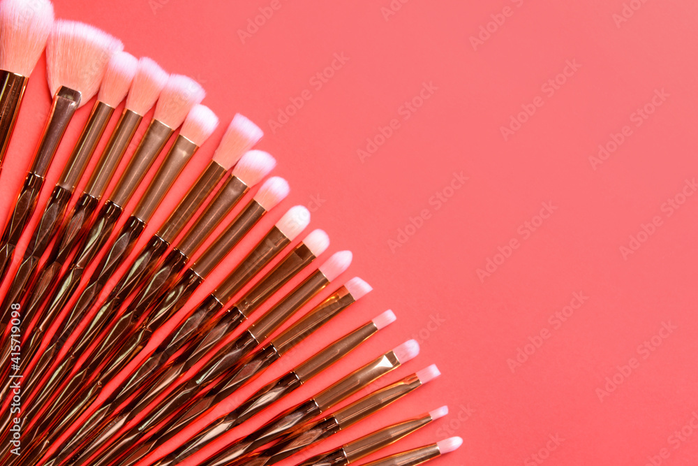 Set of makeup brushes on color background