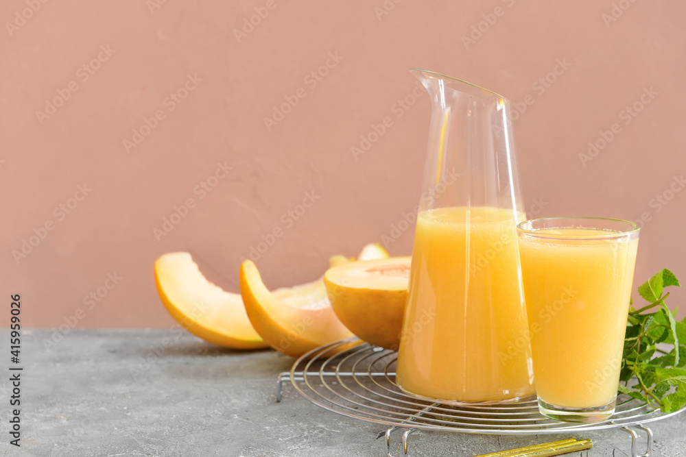 Glass and jug with melon smoothie on table