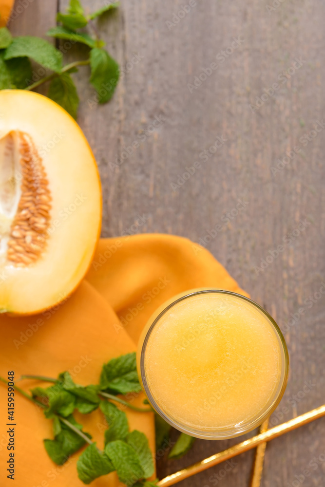 Glass with melon smoothie on wooden background