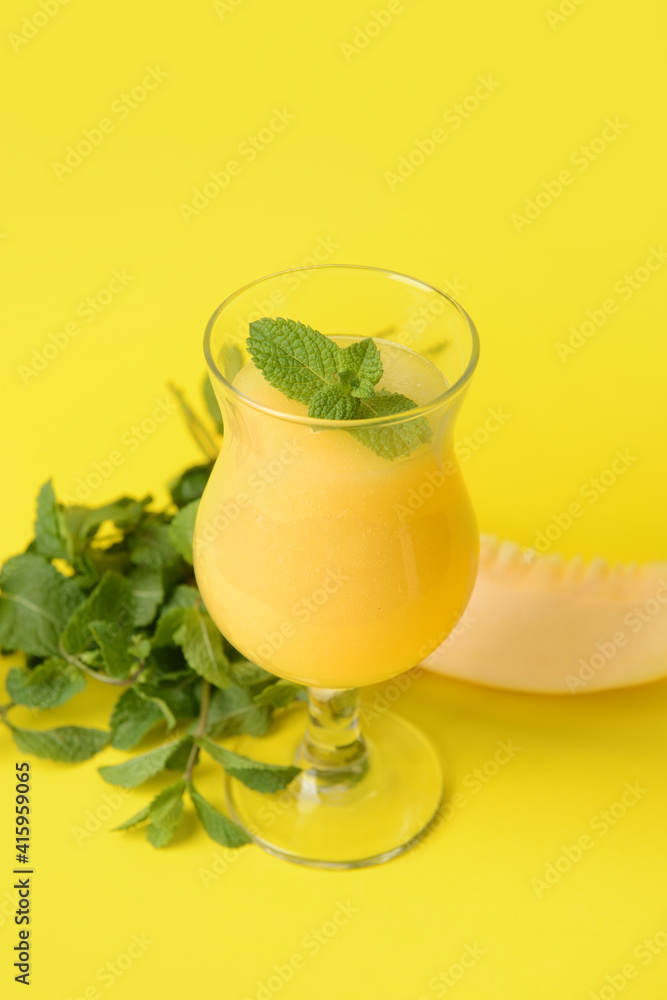 Glass with melon smoothie on color background