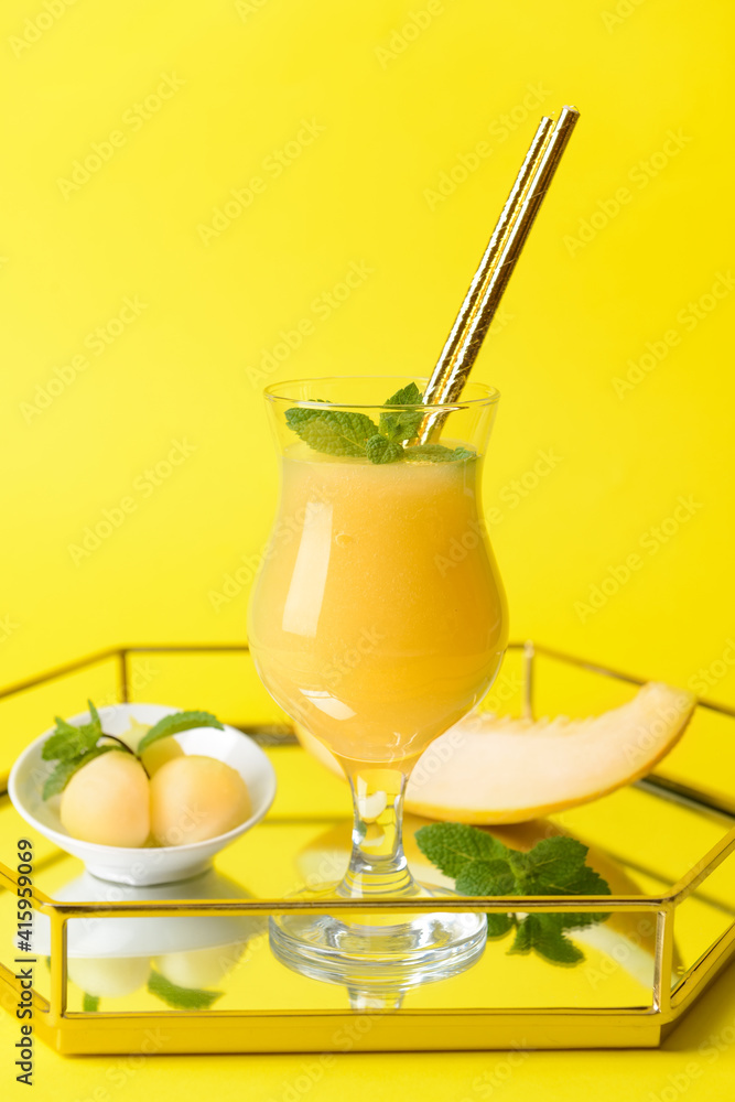 Tray with glass of melon smoothie on color background