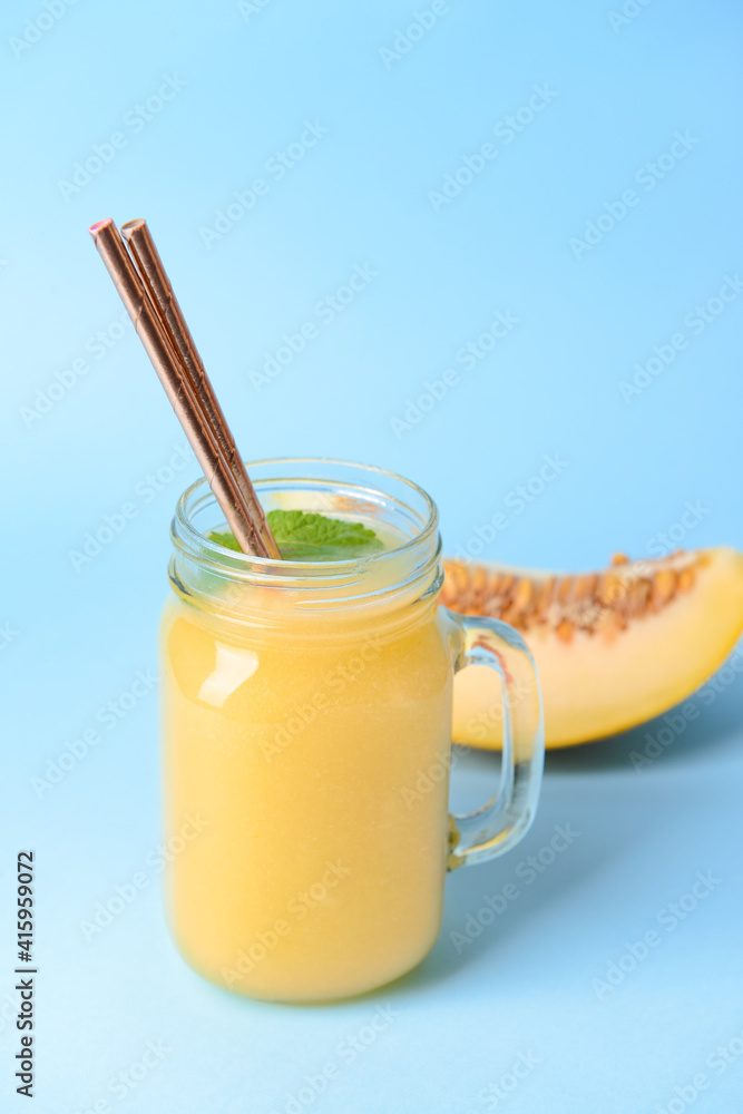 Mason jar with melon smoothie on color background