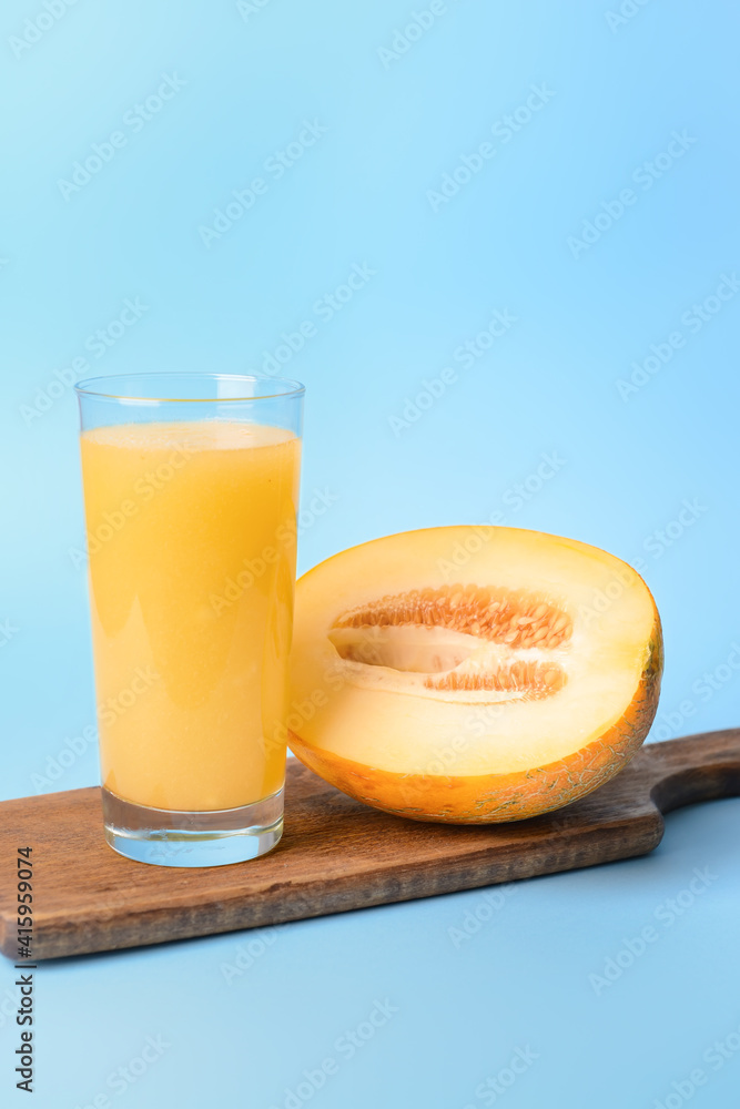 Glass with melon smoothie on color background