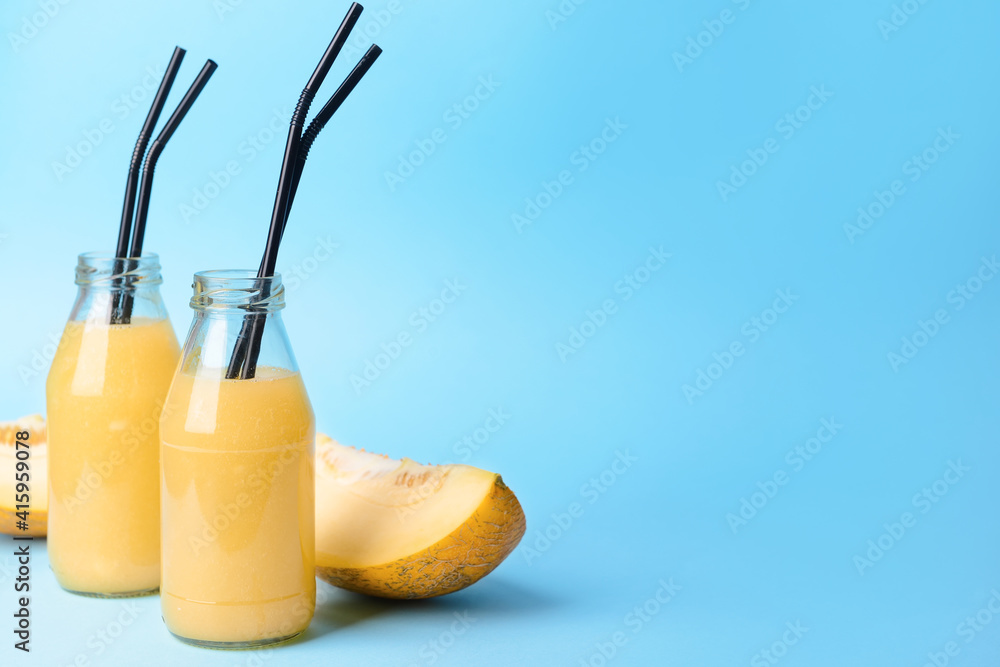 Bottles with melon smoothie on color background