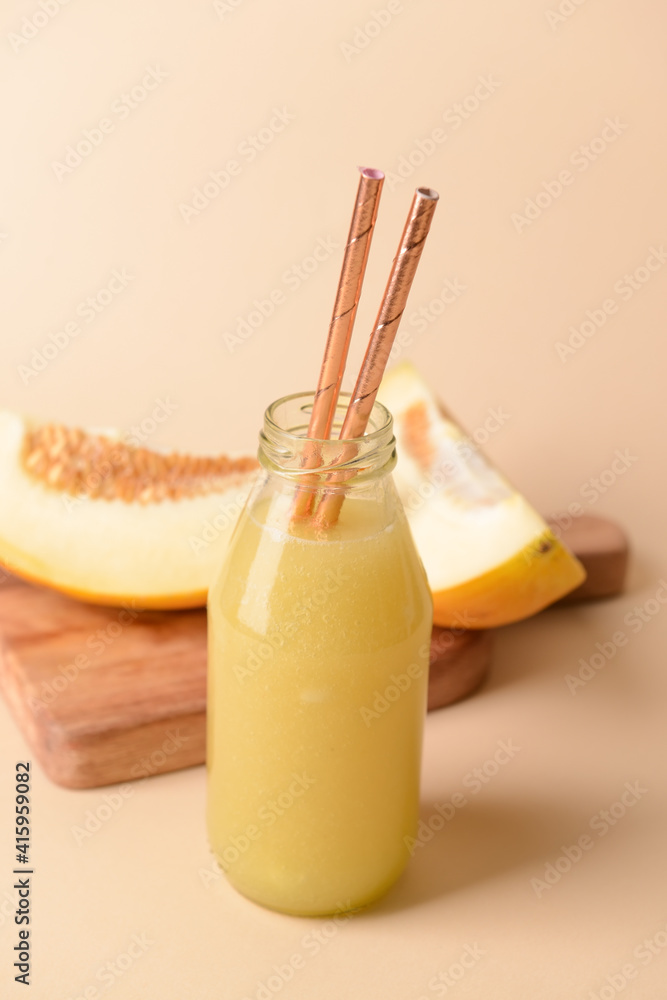 Bottle with melon smoothie on color background